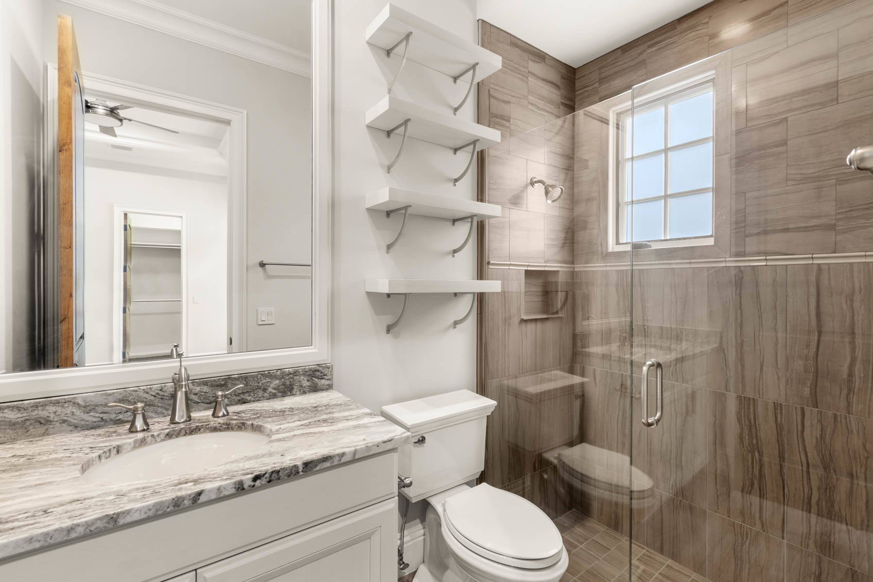 bathroom with white counter and tiled shower